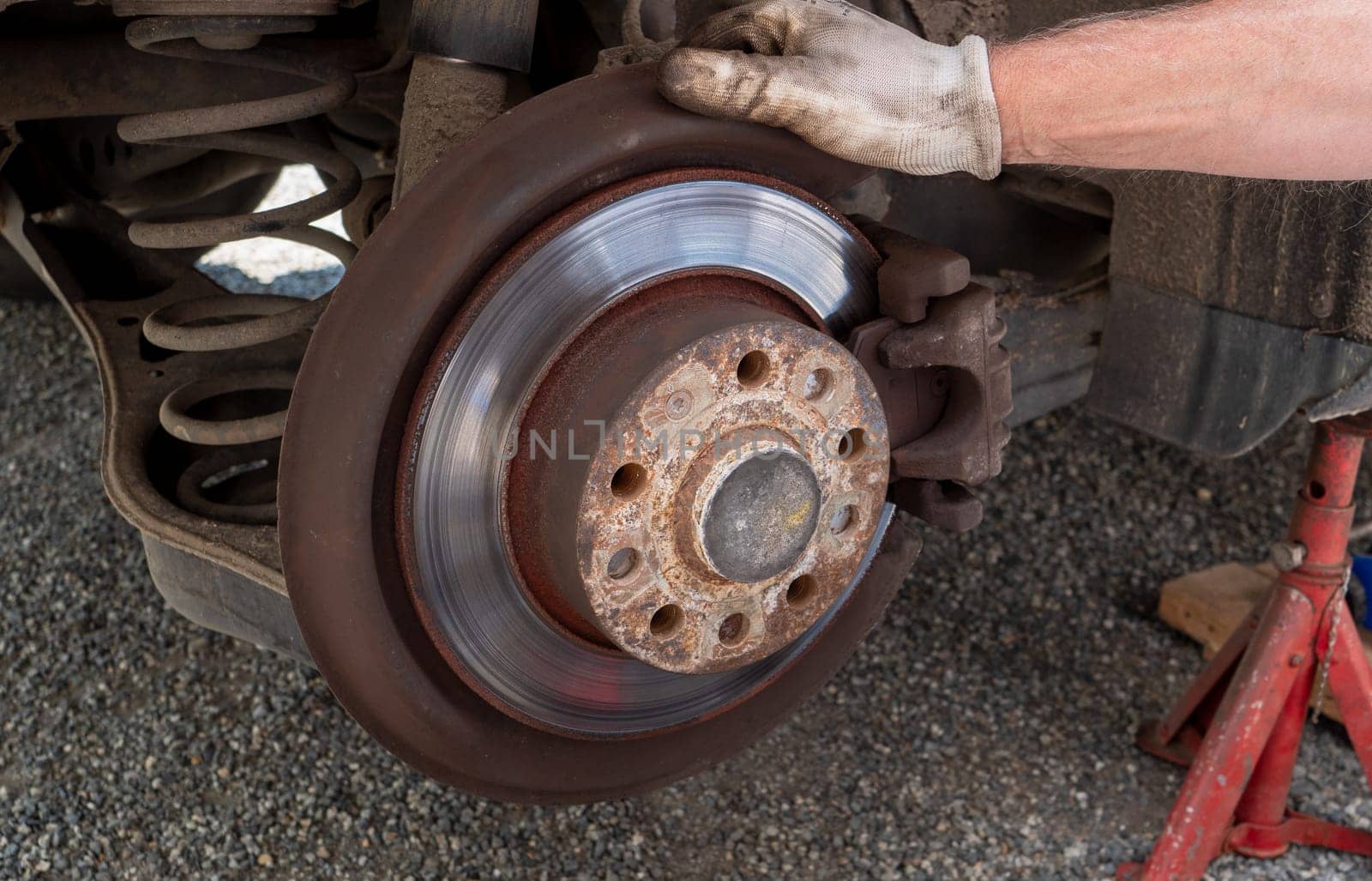 a Car mechanic repairing brakes on car