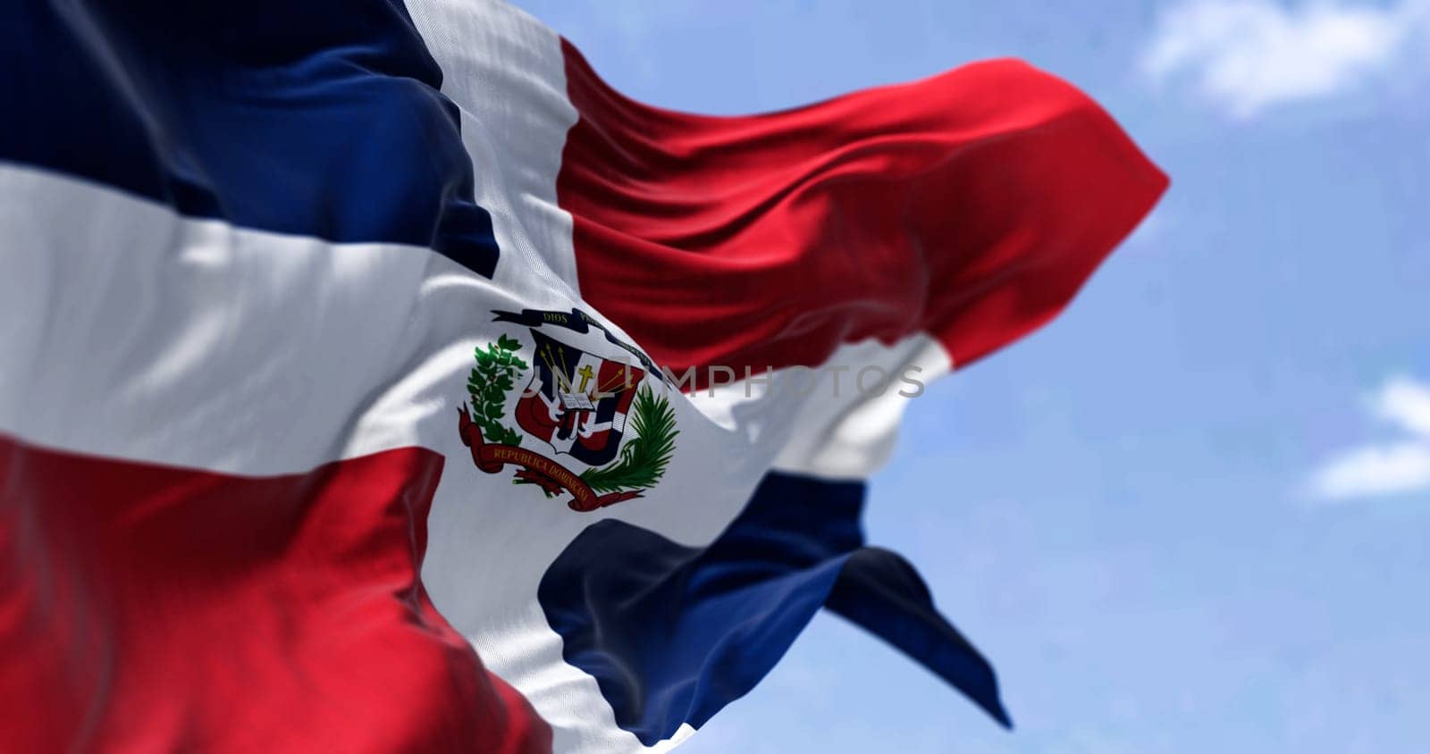 Detail of the national flag of the Dominican Republic waving in the wind on a clear day. Democracy and politics. Patriotism. Selective focus. Caribbean country. Seamless Slow motion