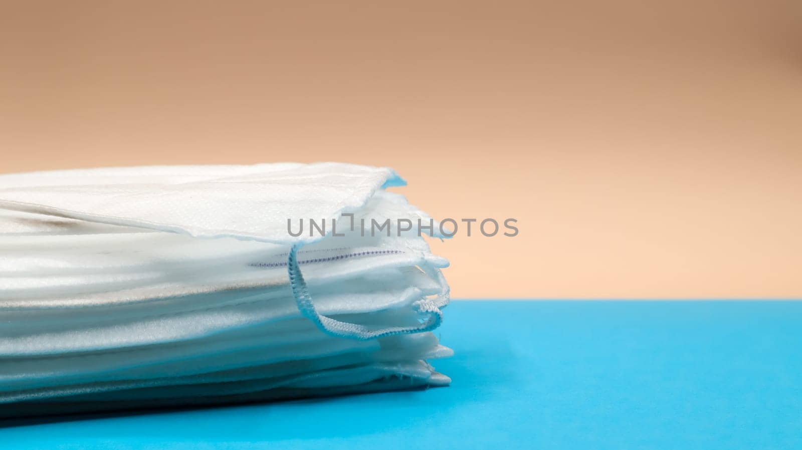 Coronavirus protection. Antiviral protective medical face masks with ear loops. Surgical mask background. Respiratory syndrome, coronavirus disease COVID-19. Many folded medical masks
