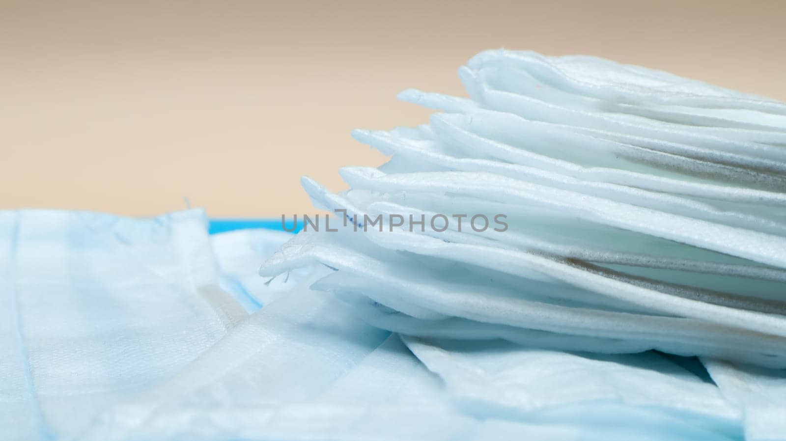 Coronavirus protection. Antiviral protective medical face masks with ear loops. Surgical mask background. Respiratory syndrome, coronavirus disease COVID-19. Many folded medical masks