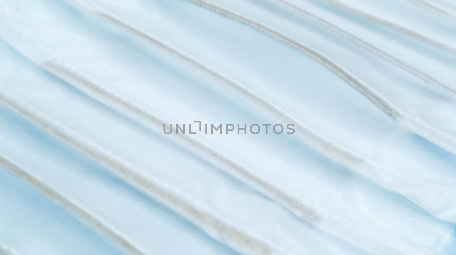 Coronavirus protection. Many antiviral protective medical face masks with ear loops spread out on a blue background. Surgical mask background. Respiratory syndrome, coronavirus disease COVID-19
