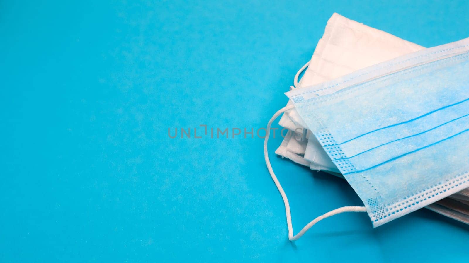 Coronavirus protection. Antiviral protective medical face masks with ear loops. Surgical mask background. Respiratory syndrome, coronavirus disease COVID-19. Many folded medical masks