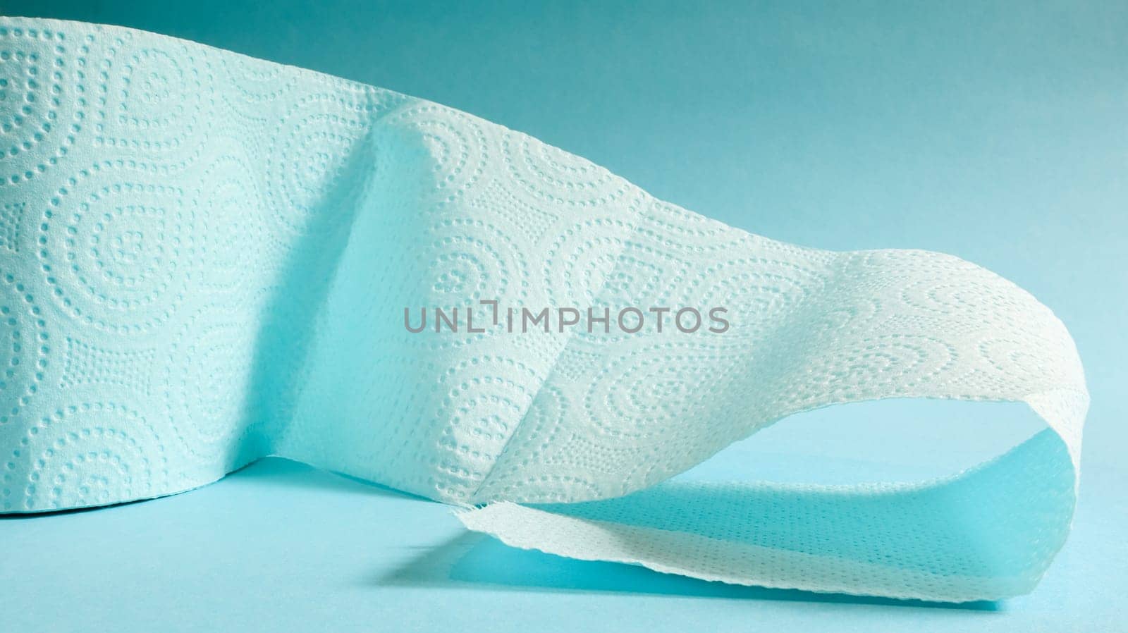 Blue roll of modern toilet paper on a blue background. A paper product on a cardboard sleeve, used for sanitary purposes from cellulose with cutouts for easy tearing. Embossed drawing.