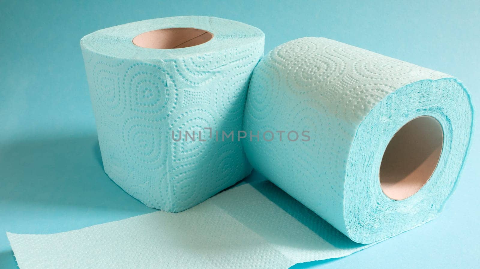 Blue roll of modern toilet paper on a blue background. A paper product on a cardboard sleeve, used for sanitary purposes from cellulose with cutouts for easy tearing. Embossed drawing.