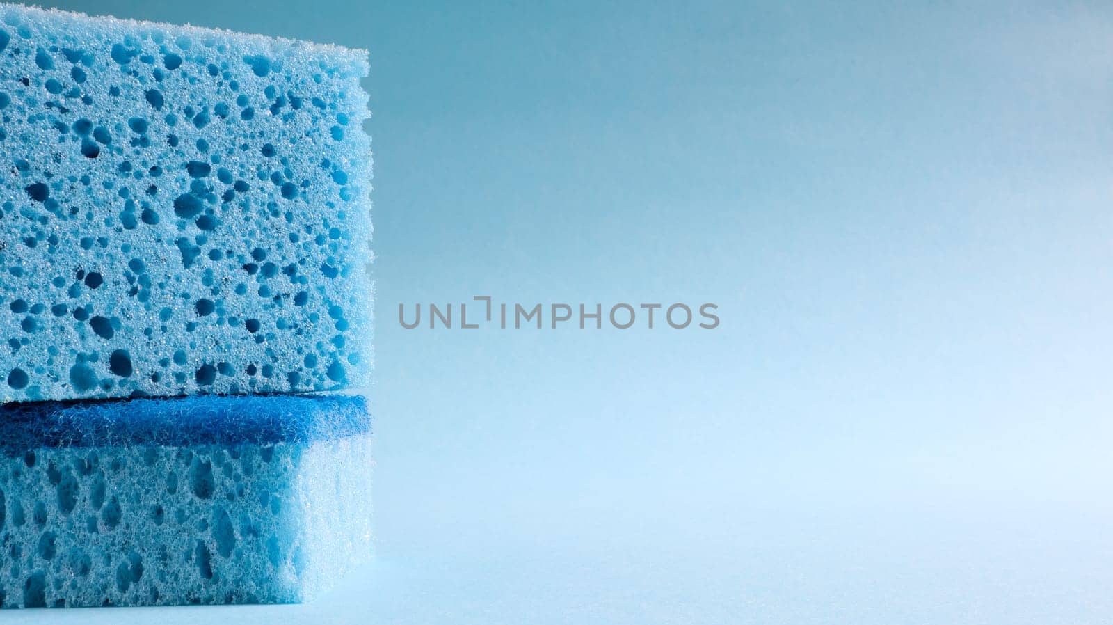 Two blue sponges used for washing and erasing dirt used by housewives in everyday life. They are made of porous material such as foam. Detergent retention, which allows you to spend it economically.