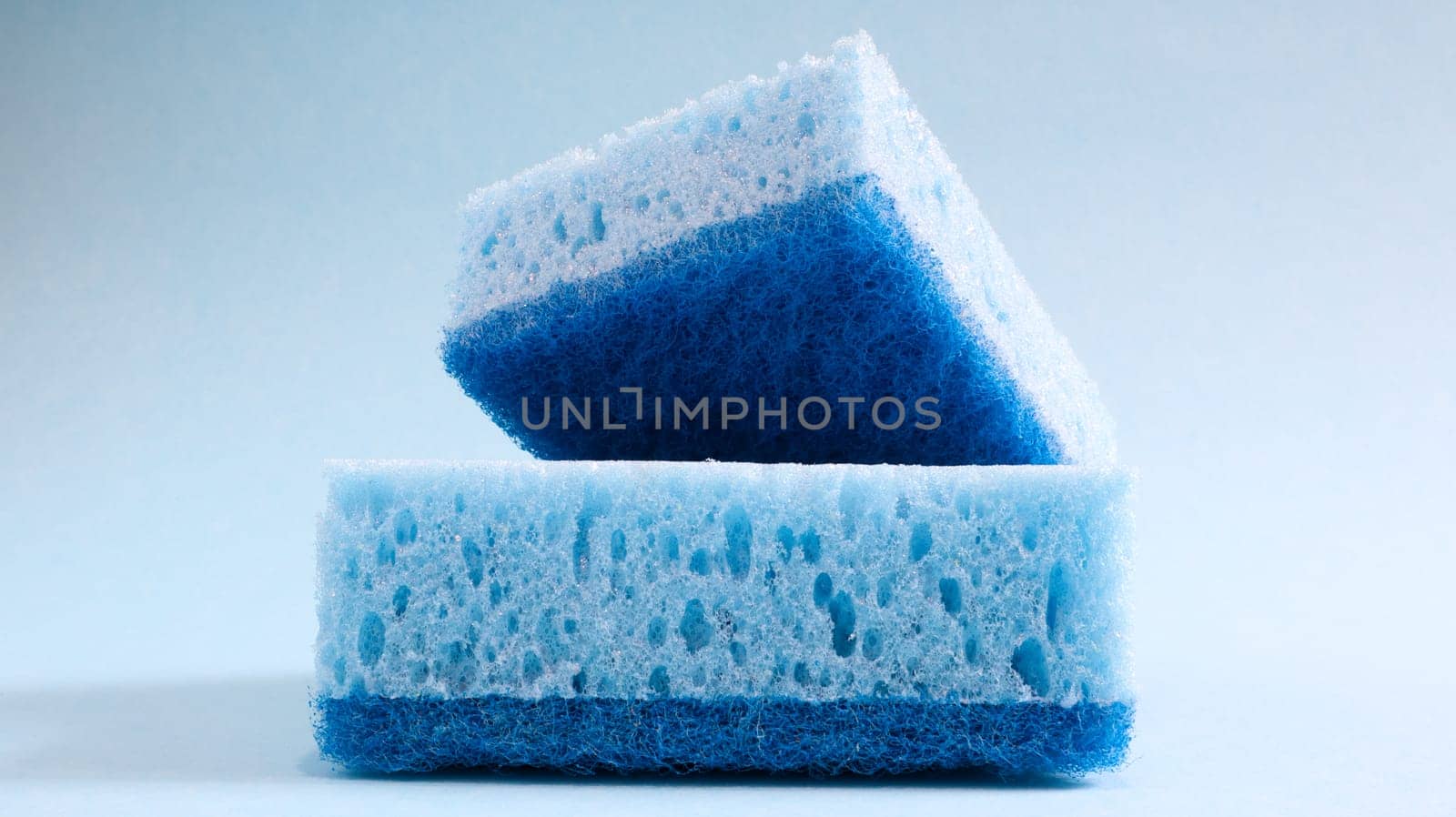 Two blue sponges used for washing and erasing dirt used by housewives in everyday life. They are made of porous material such as foam. Detergent retention, which allows you to spend it economically.