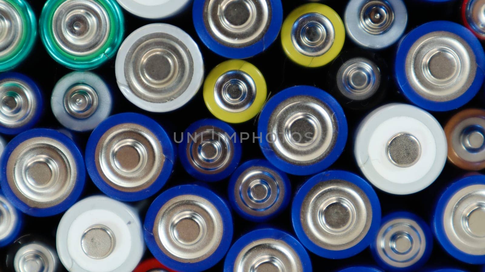 Lots of used household alkaline batteries type AA, AAA, collected for recycling. Recycling and ecology problems. Top view of a background of used batteries of different types and sizes