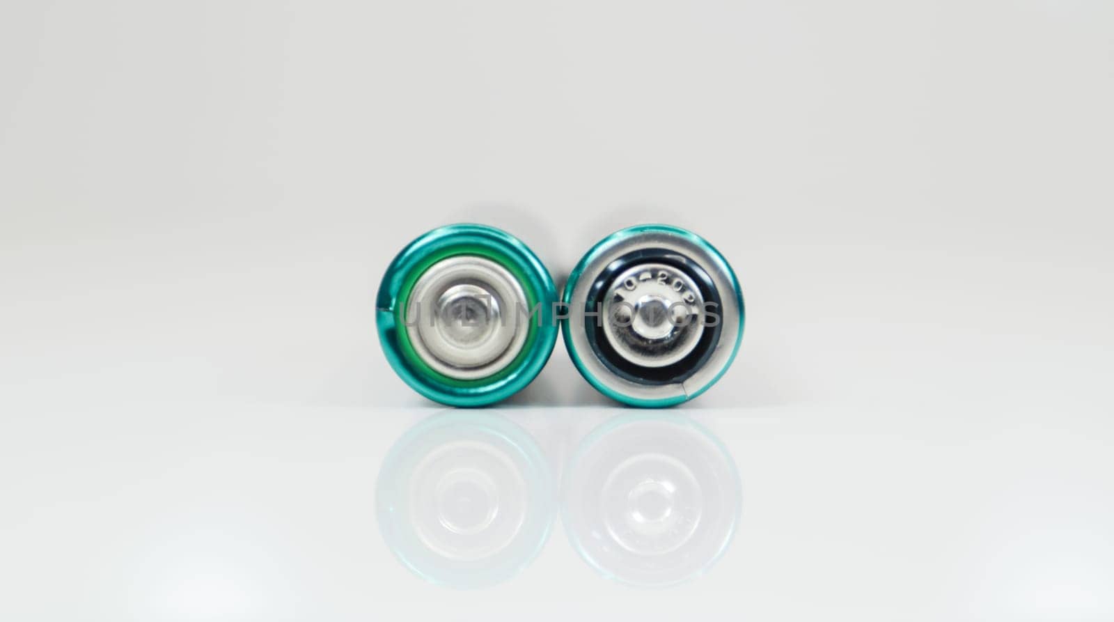 Two alkaline batteries on a white background with reflection. Energy supply and recycling concept. Copy space. Minimalism. Eliment AA is the most common type of galvanic batteries and accumulators