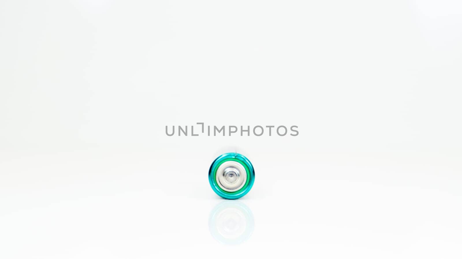 One alkaline battery on a white background with reflection. Energy supply and recycling concept. Copy space. Minimalism. Eliment AA is the most common type of galvanic batteries and accumulators