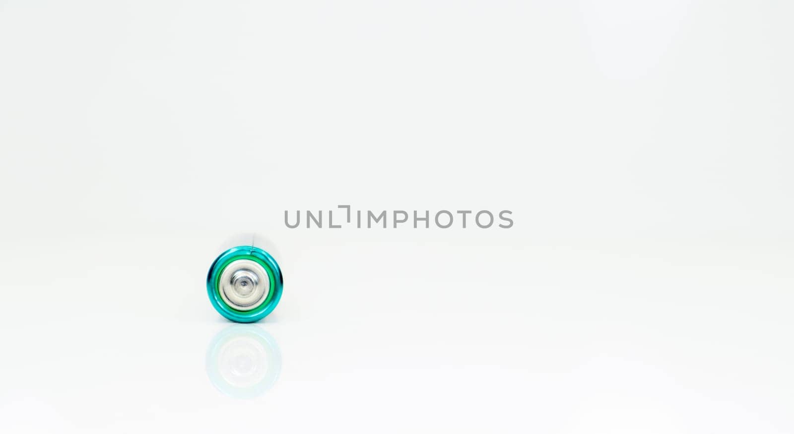 One alkaline battery on a white background with reflection. Energy supply and recycling concept. Copy space. Minimalism. Eliment AA is the most common type of galvanic batteries and accumulators