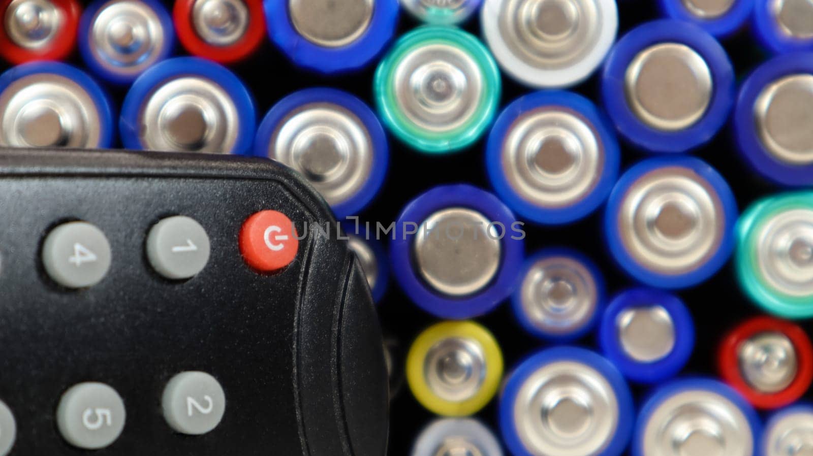 TV remote control with disposable AAA and AA alkaline batteries. Battery replacement, spare parts. Recycling concept. Lots of batteries