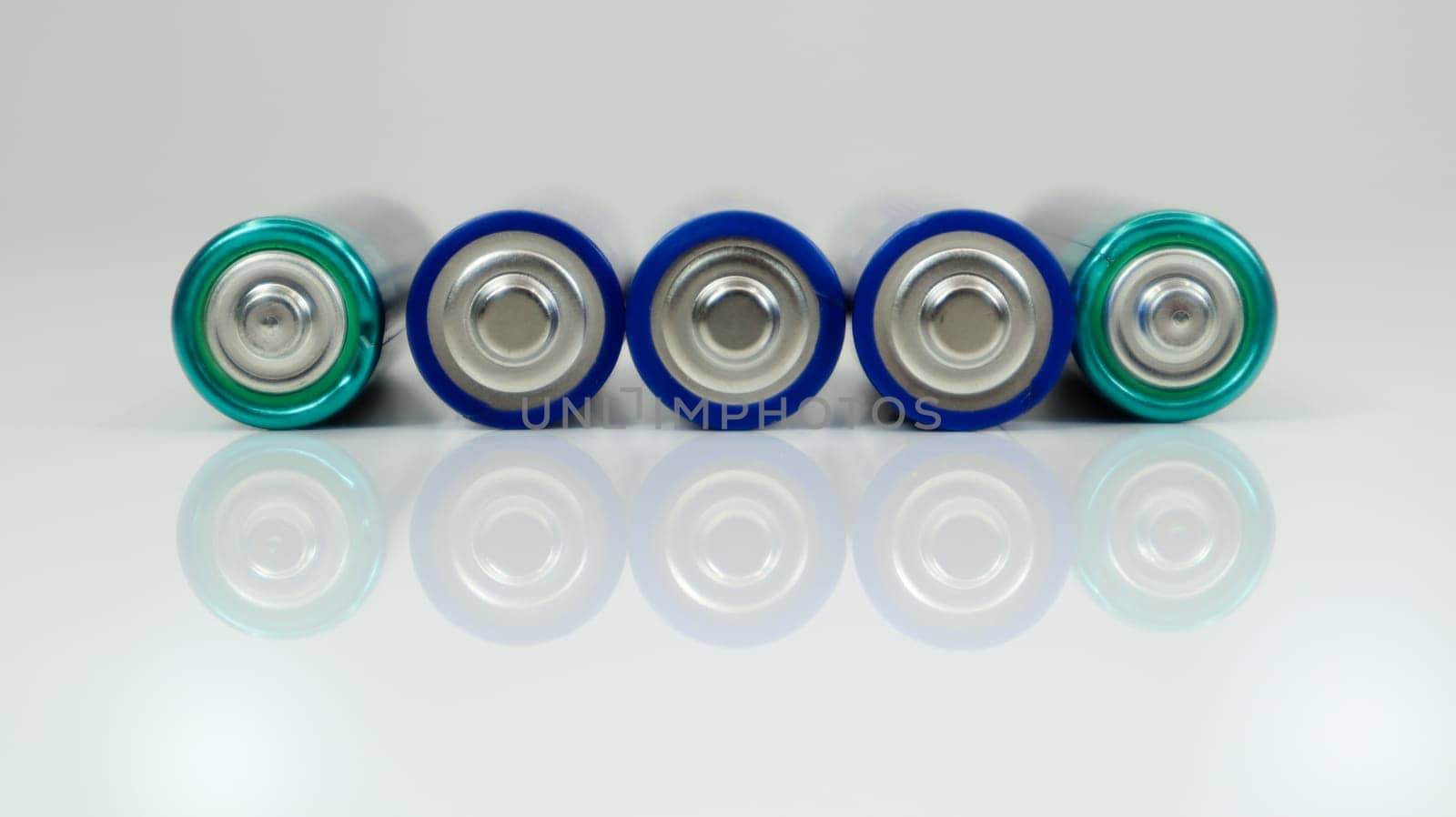 AA alkaline rechargeable batteries on white glossy background with reflection with copy space