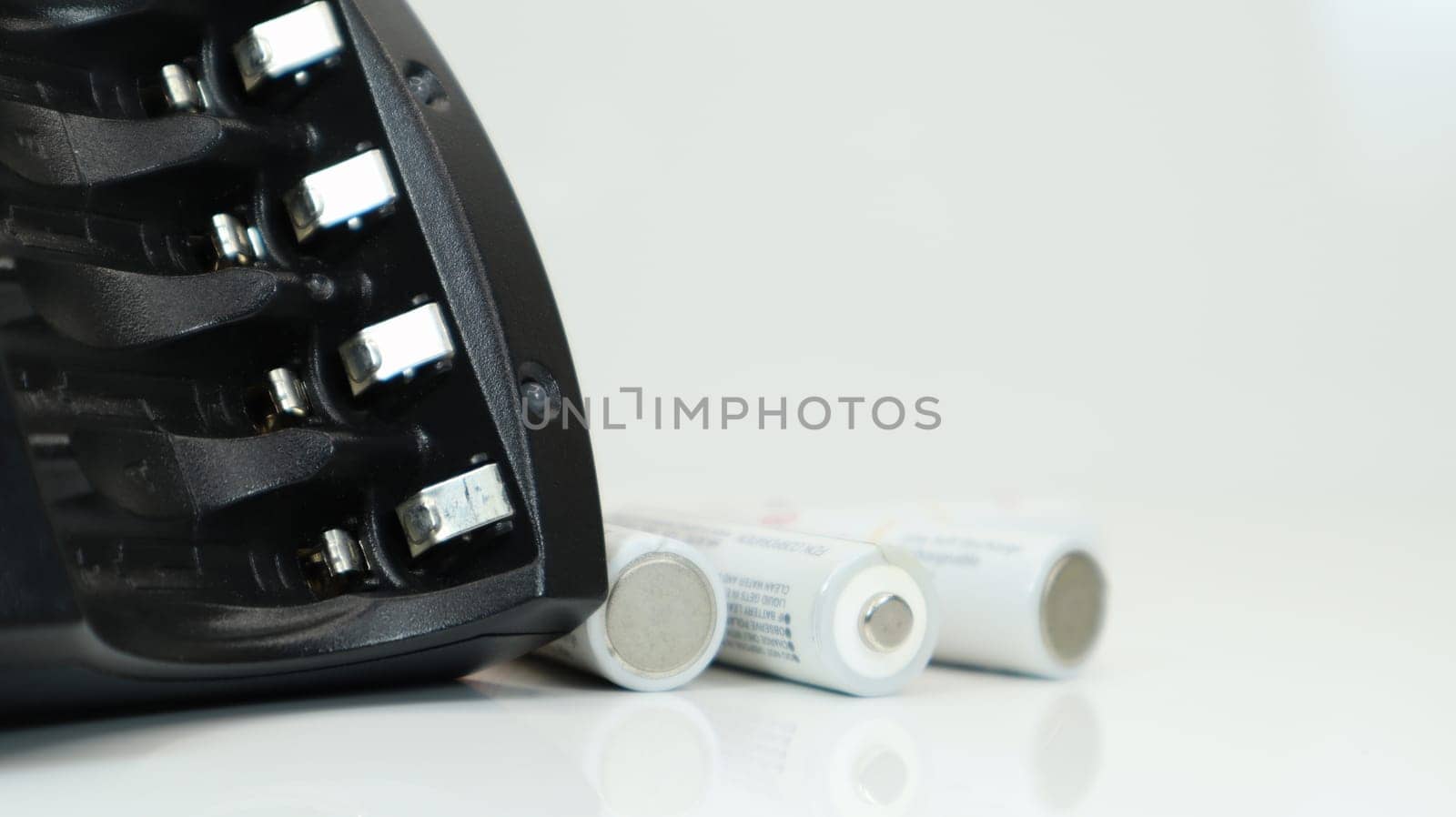 Fast charger for four AA rechargeable batteries in black on a white background. No batteries