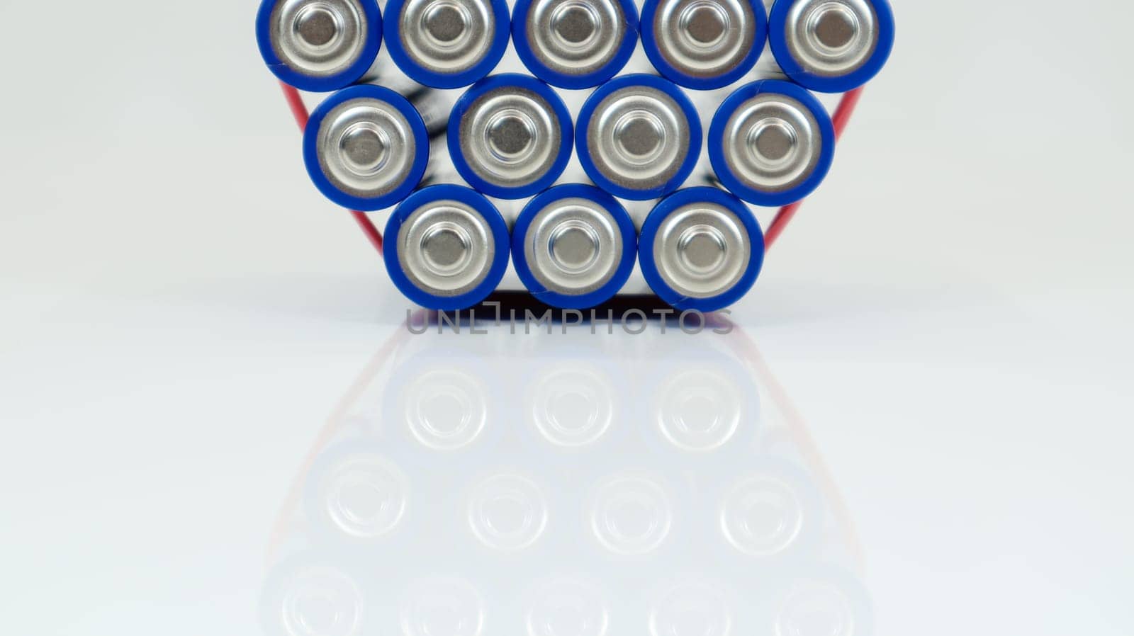 Lots of AA and AAA alkaline batteries on a white background. Ecological recycling concept. The terminals of the disposable batteries are close together and form a beautiful backdrop. Energy source