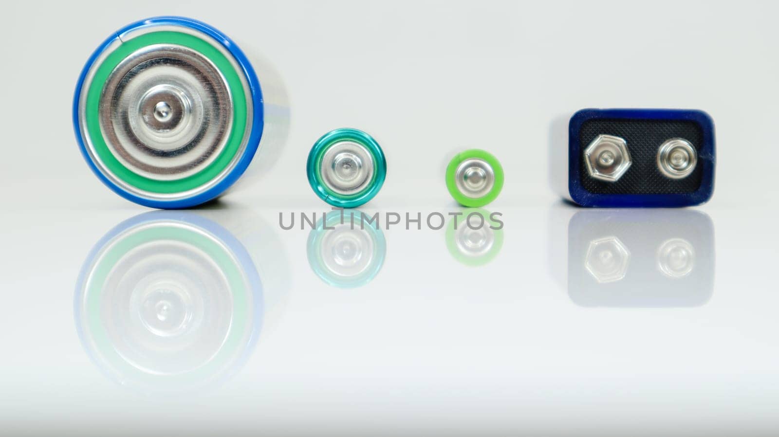 Battery type D or C, PP3, AA, AAA on a white background with reflection. View of metal alkaline batteries with copy space. Mandatory processing