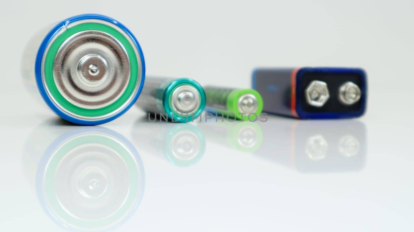 Battery type D or C, PP3, AA, AAA on a white background with reflection. View of metal alkaline batteries with copy space. Mandatory processing