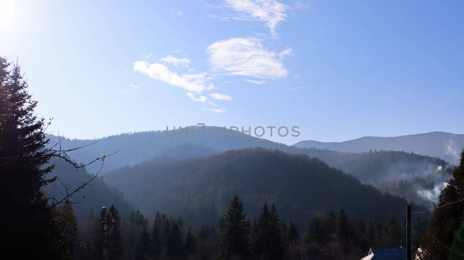 Autumn rain and fog on the mountain hills. Misty autumn forest covered with low clouds. Ukraine. Spruce forest trees on the hills of mountains sticking through the morning fog over autumn landscapes