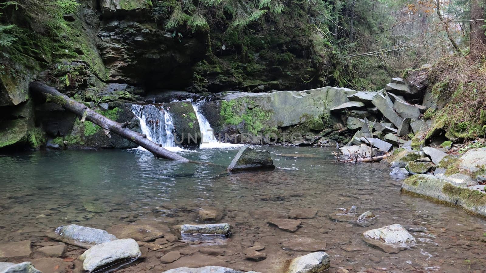 Waterfalls in a small canyon with stone walls. Beautiful cascade in the mountains. river in the Carpathians in the mountain autumn forest. scenic view, the movement of water