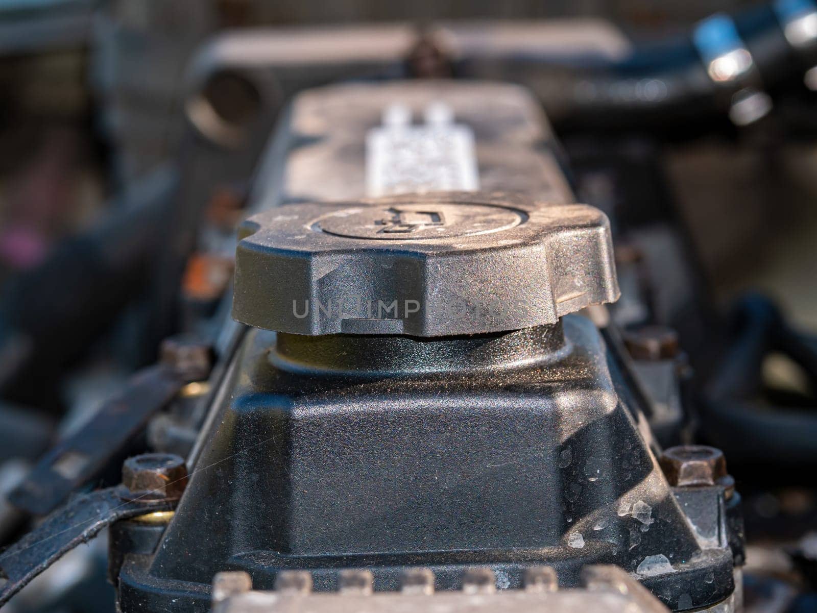 Filler cap for filling engine oil into a car engine. Engine oil filling point. Service service. Car maintenance and repair. Repair service workshop. Motor vehicle. Part of the car.
