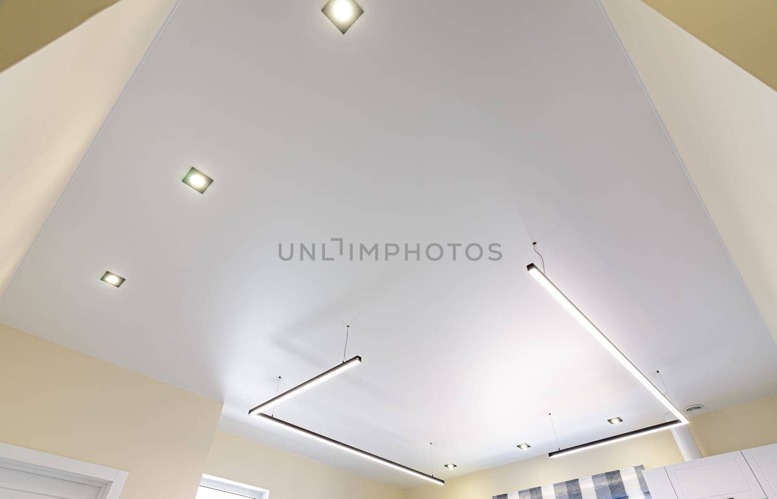 Modern white matte stretch ceiling with zoned lighting