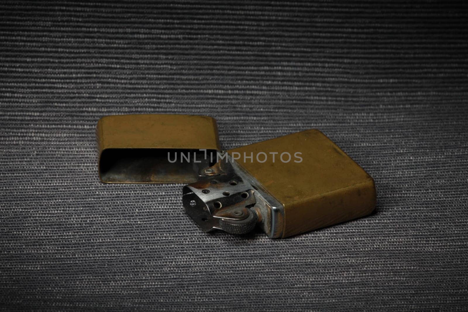 old brass petrol lighter on a dark background close-up, still life