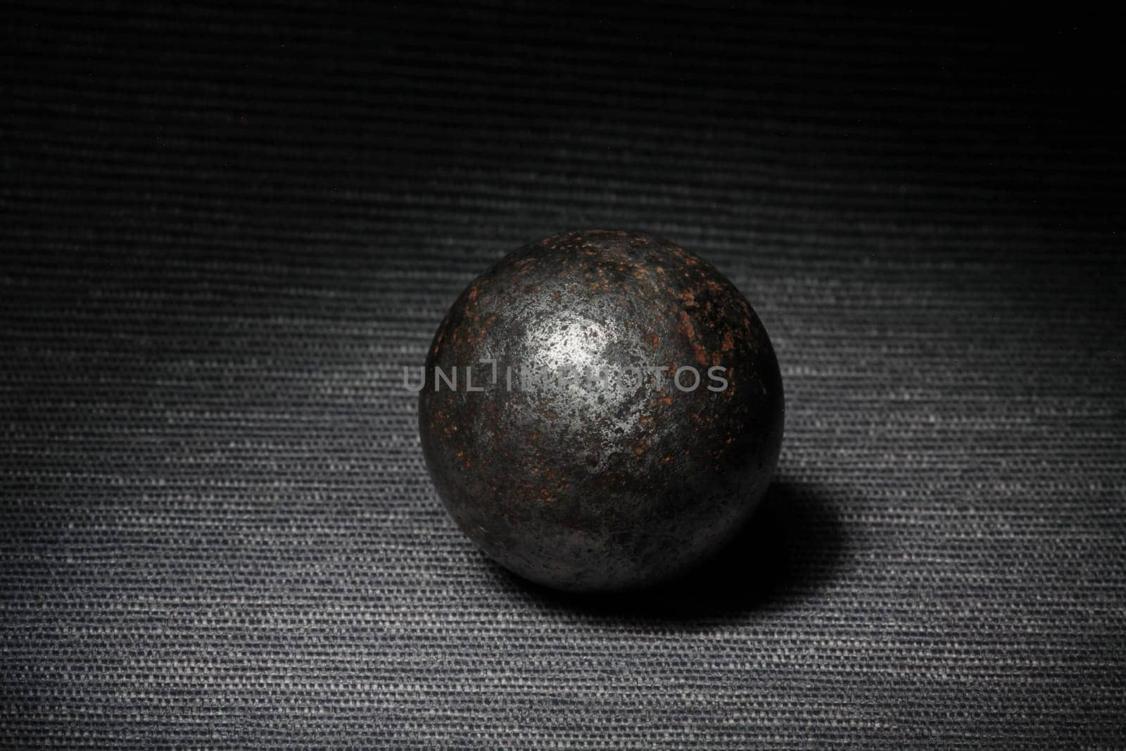 steel rusty ball on a dark background, still life
