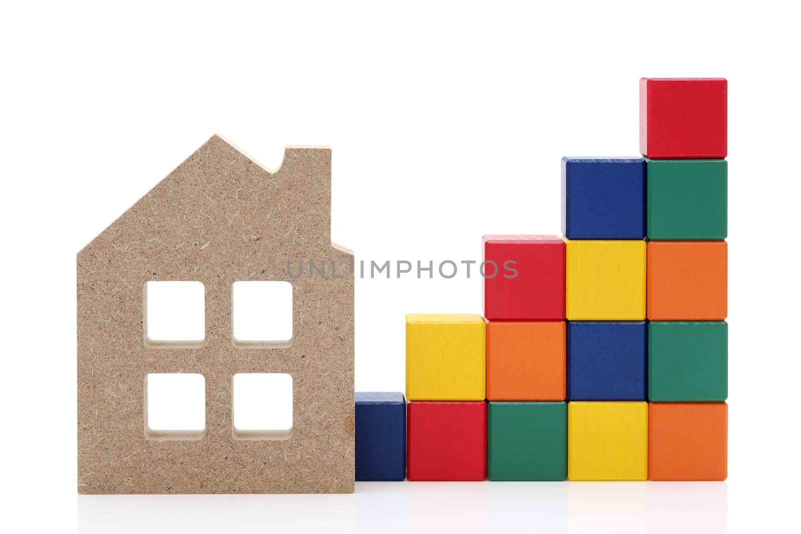 small toy house and wooden colorful building blocks on white background