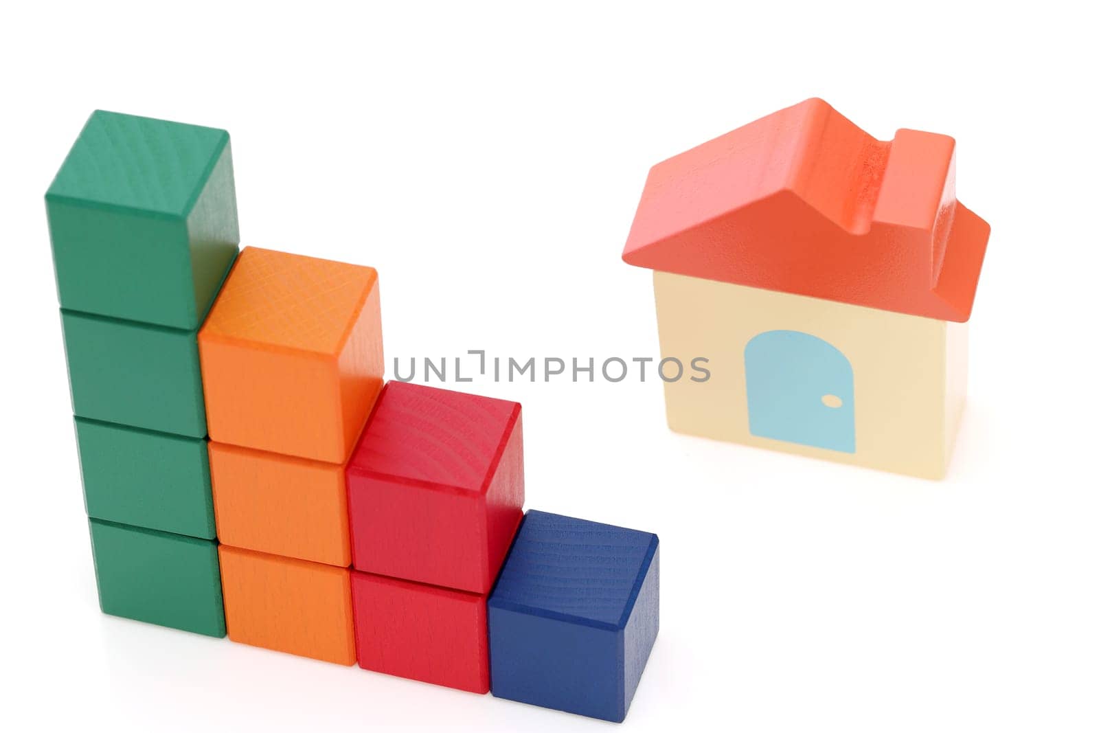 small toy house and wooden colorful building blocks on white background