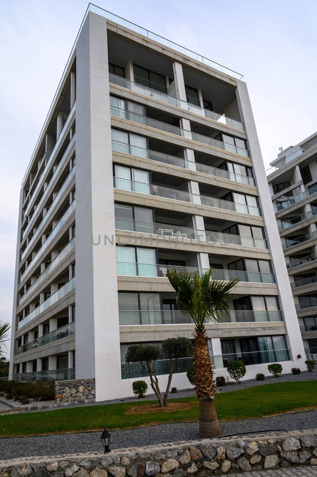 A striking building features sleek lines and modern design in a well-kept green space with shrubs.