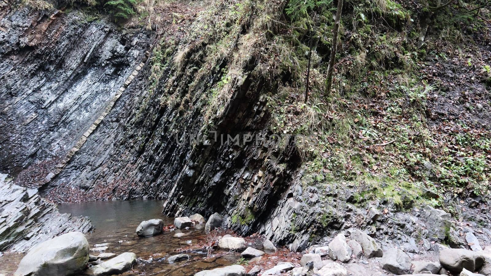 Waterfalls in a small canyon with stone walls. Beautiful cascade in the mountains. river in the Carpathians in the mountain autumn forest. scenic view, the movement of water