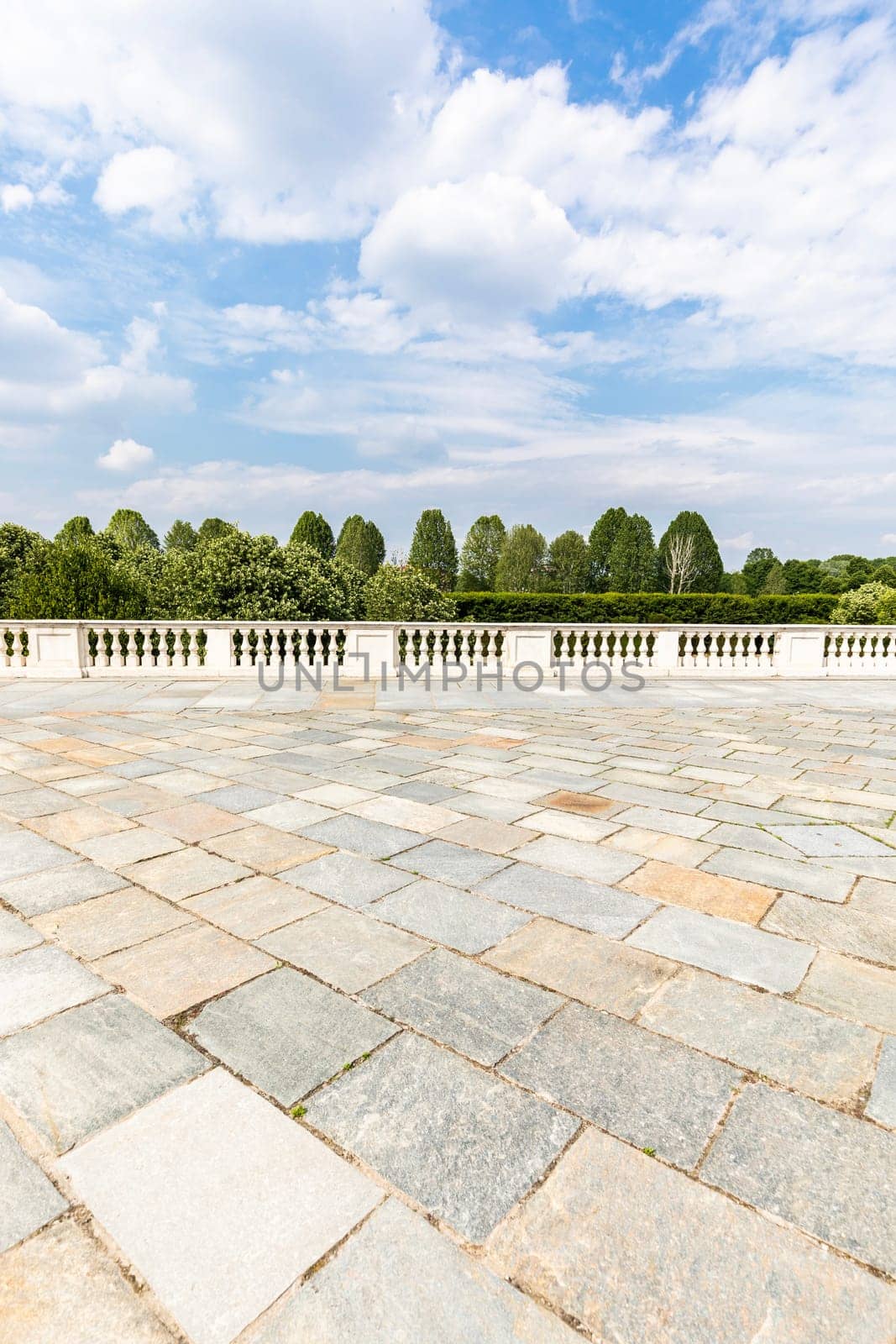 Exterior with old grey floor made of stone. Vintage textured pavement and blue sky in the background.