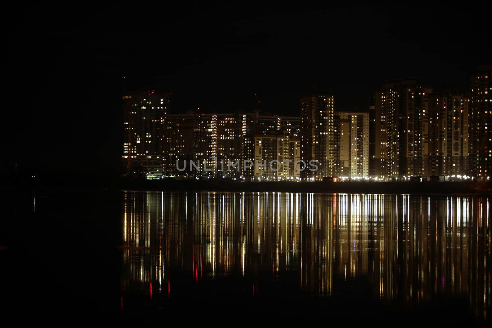 night cityscape light in the windows of skyscrapers is reflected in the river