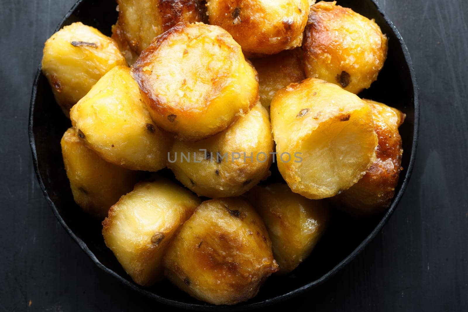 close up of  pan of rustic golden english roasted duck fat potatoes