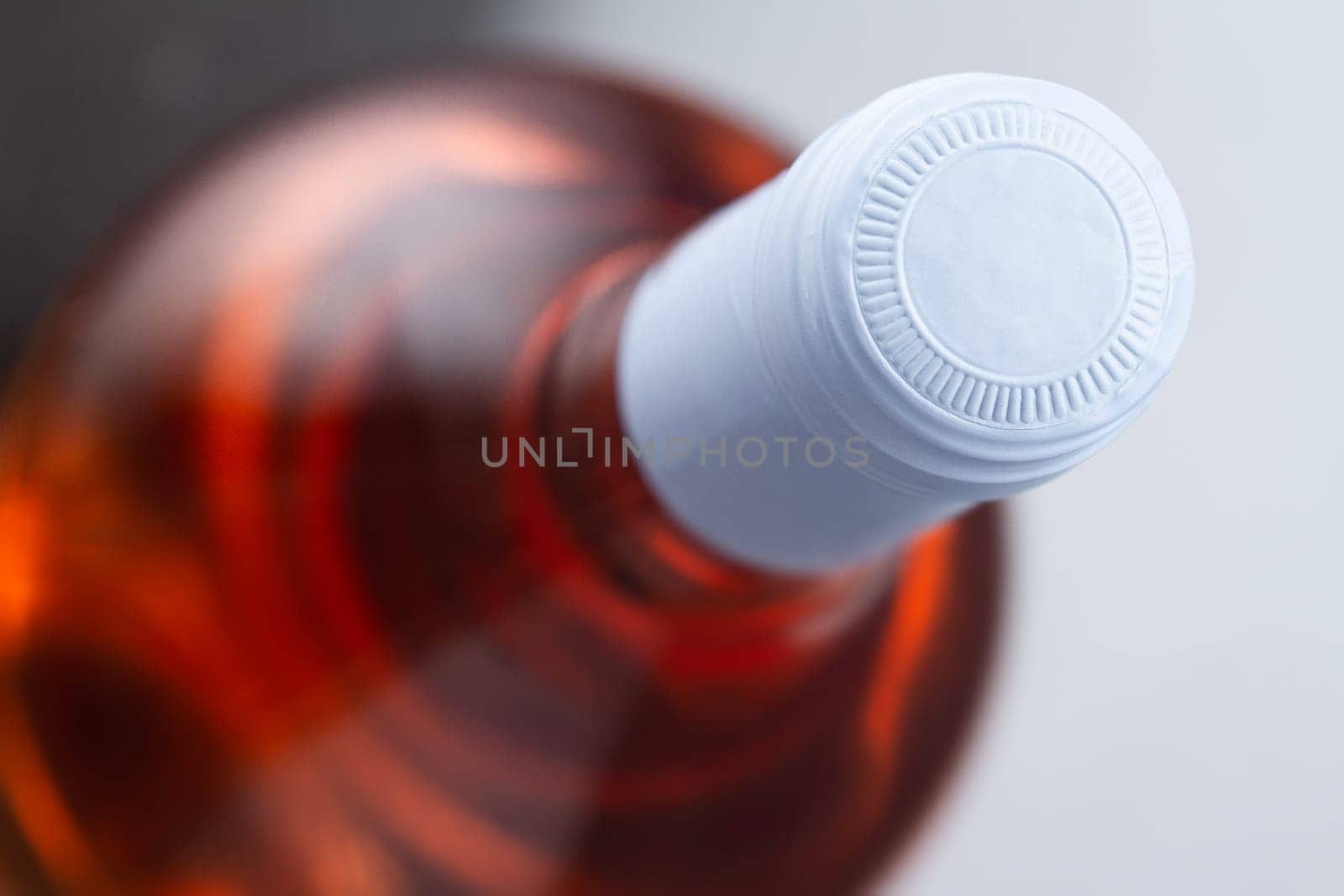 top view closeup of rose wine bottle mockup with light blue blank cap enclosure in focus