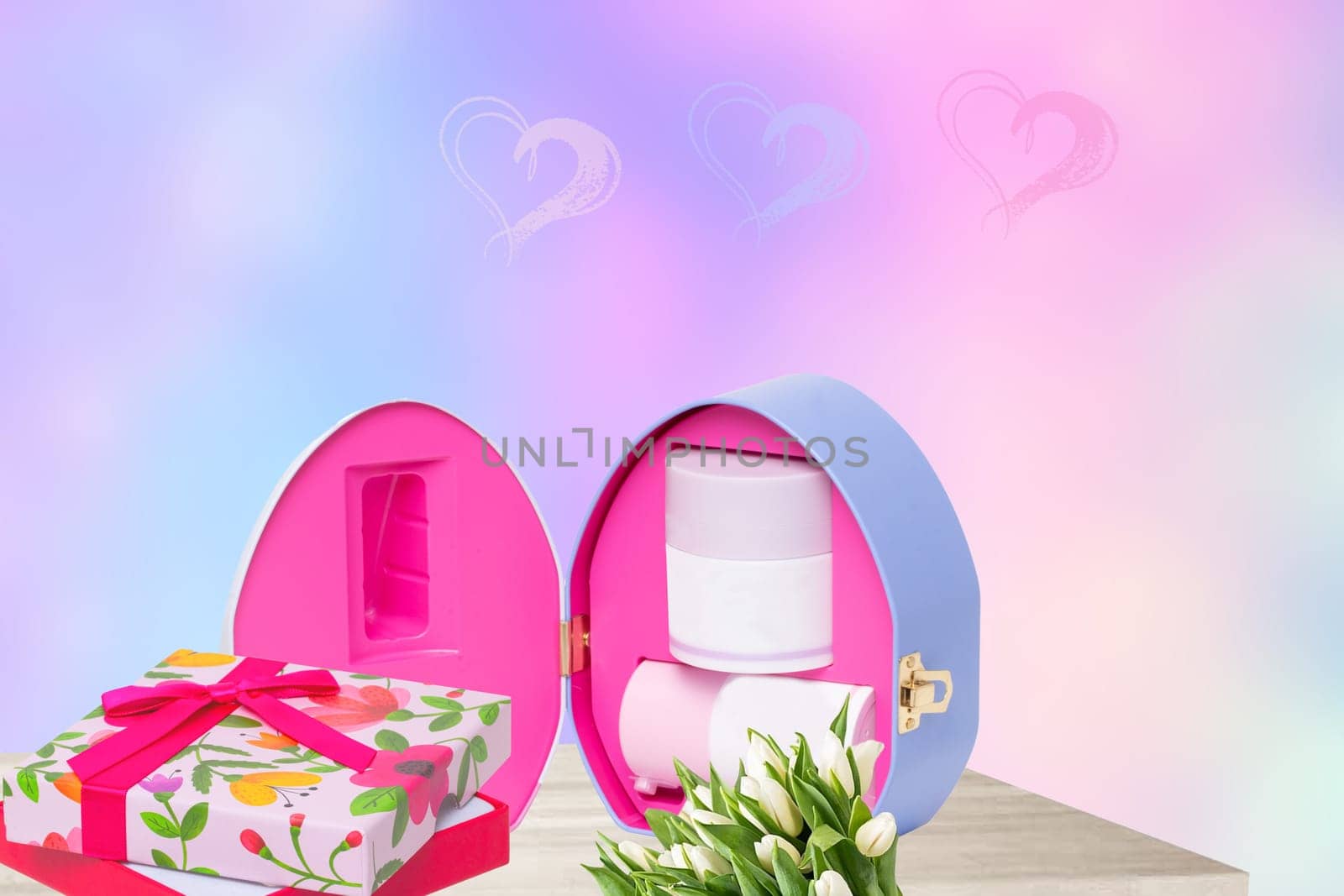 Happy Valentine or Mothers Day template. Decorative cosmetic box a gift box and a bundle of flowers on table over abstract hearts bachground. Space for your text design.