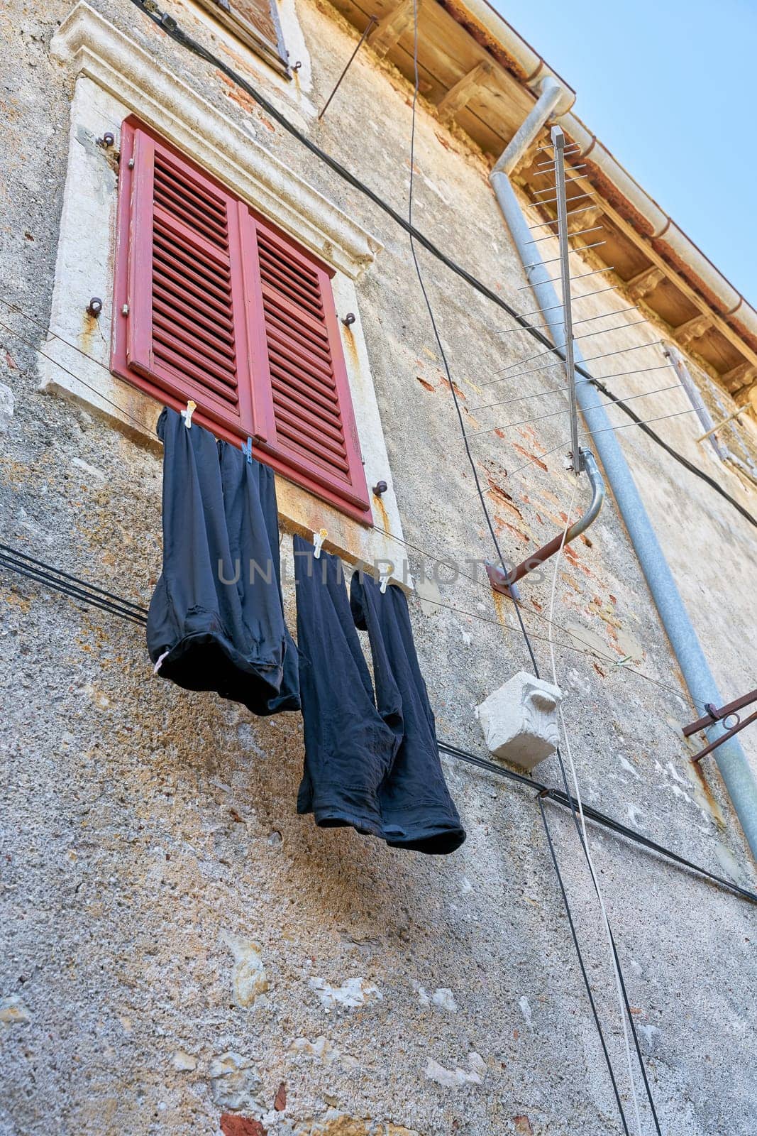 Clothesline with pants on a facade in the old town of Krk in Croatia