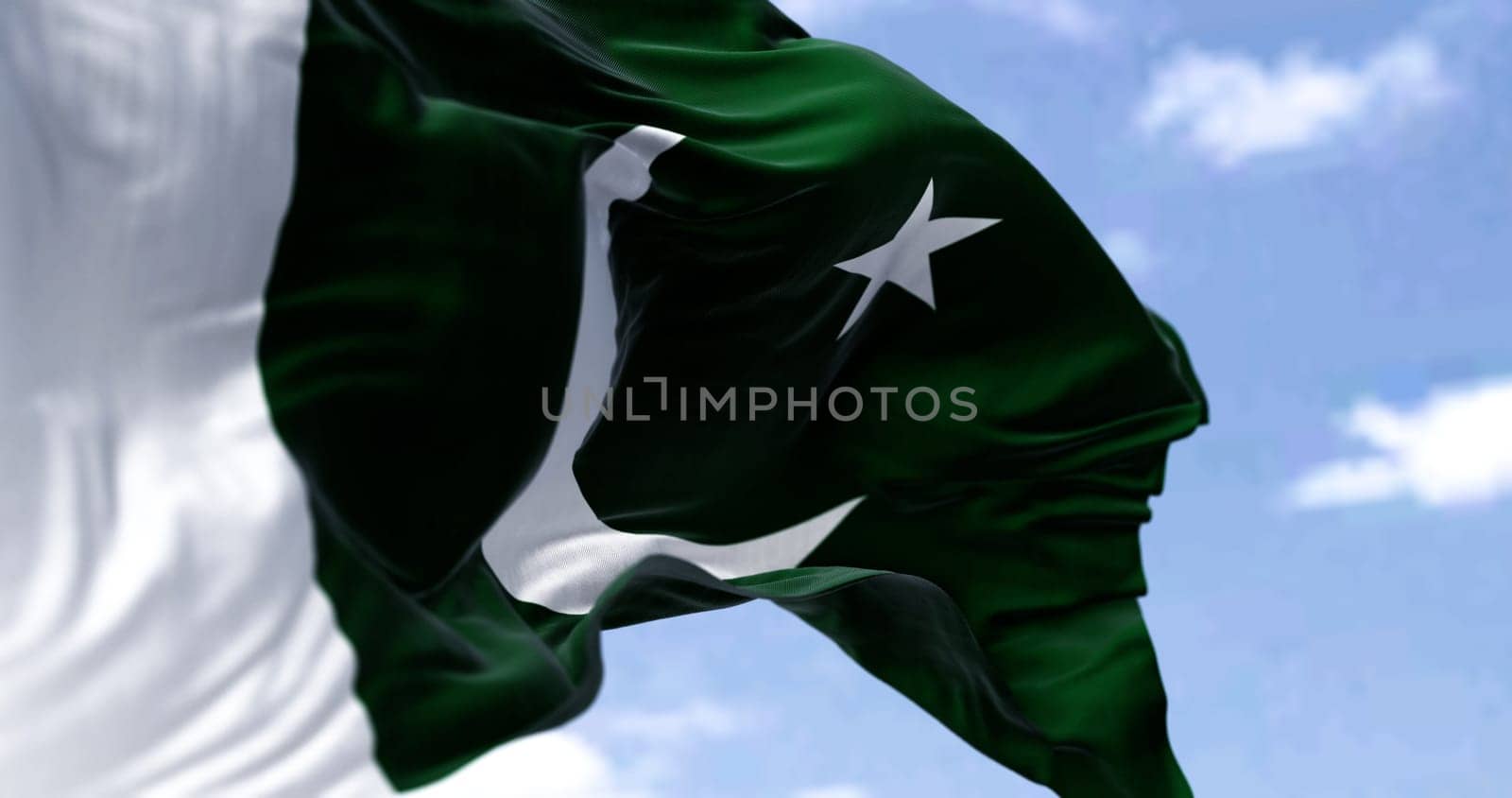 Detail of the national flag of Pakistan waving in the wind on a clear day. Democracy and politics. Patriotism. Selective focus. South Asian country.