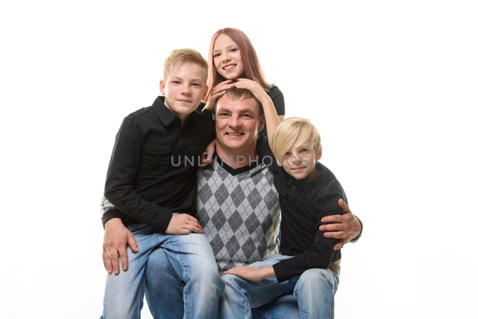Half-length portrait of a father and three children in casual clothes on a white background