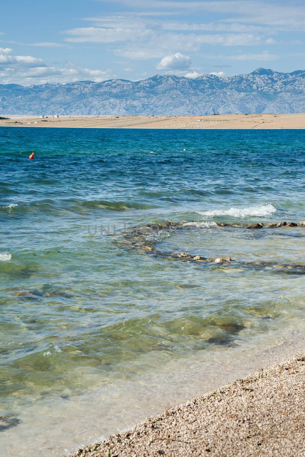 Beautiful coast, blue sea and mountains in the distance. Nice view of the blue Adriatic sea during a sunny day.