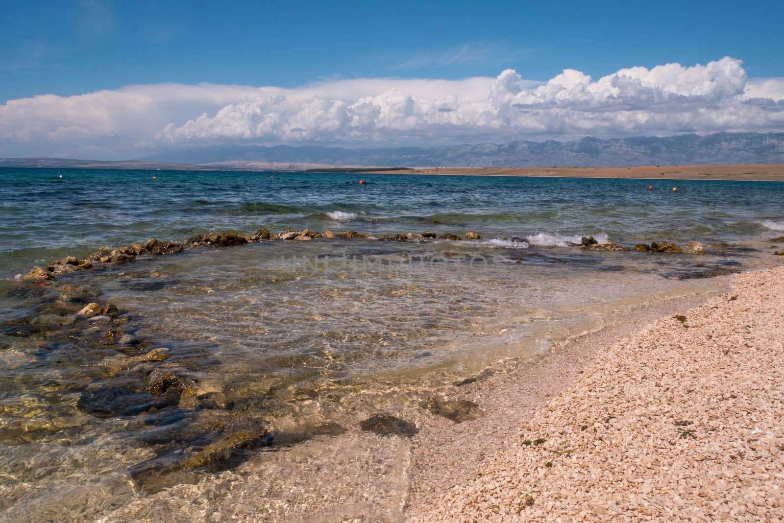 Beautiful coast, blue sea and mountains in the distance. Nice view of the blue Adriatic sea during a sunny day.
