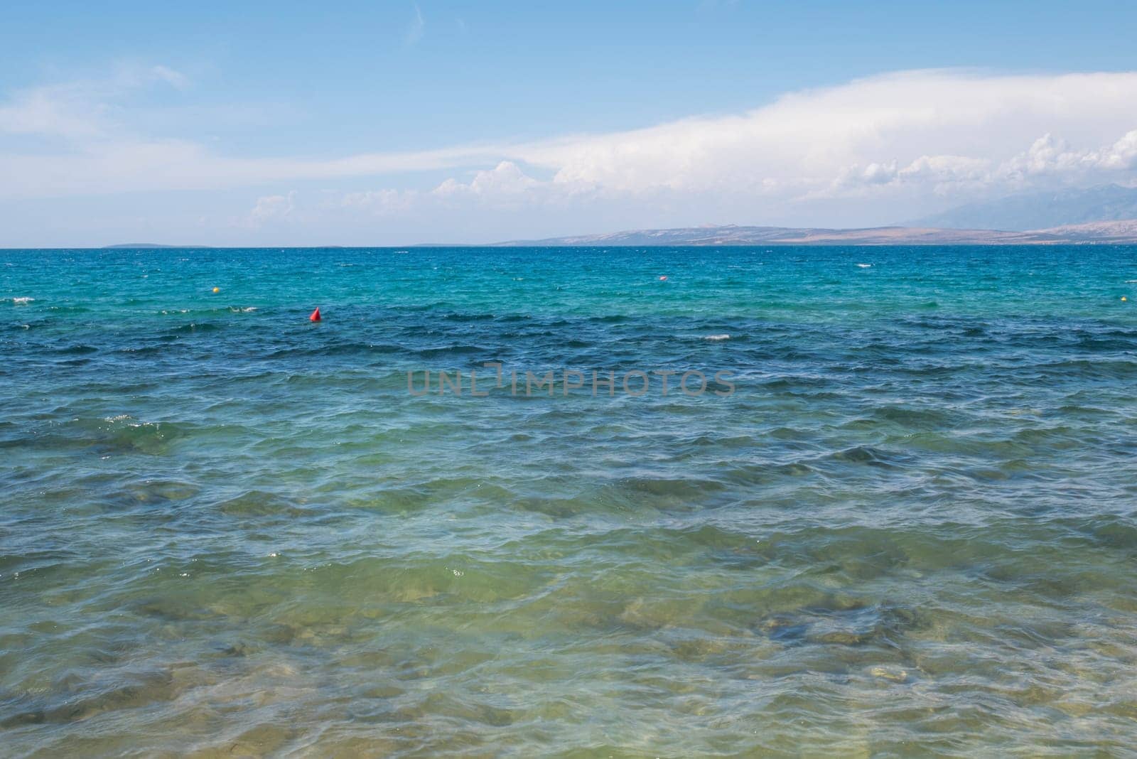 Beautiful coast, blue sea and mountains in the distance. Nice view of the blue Adriatic sea during a sunny day.