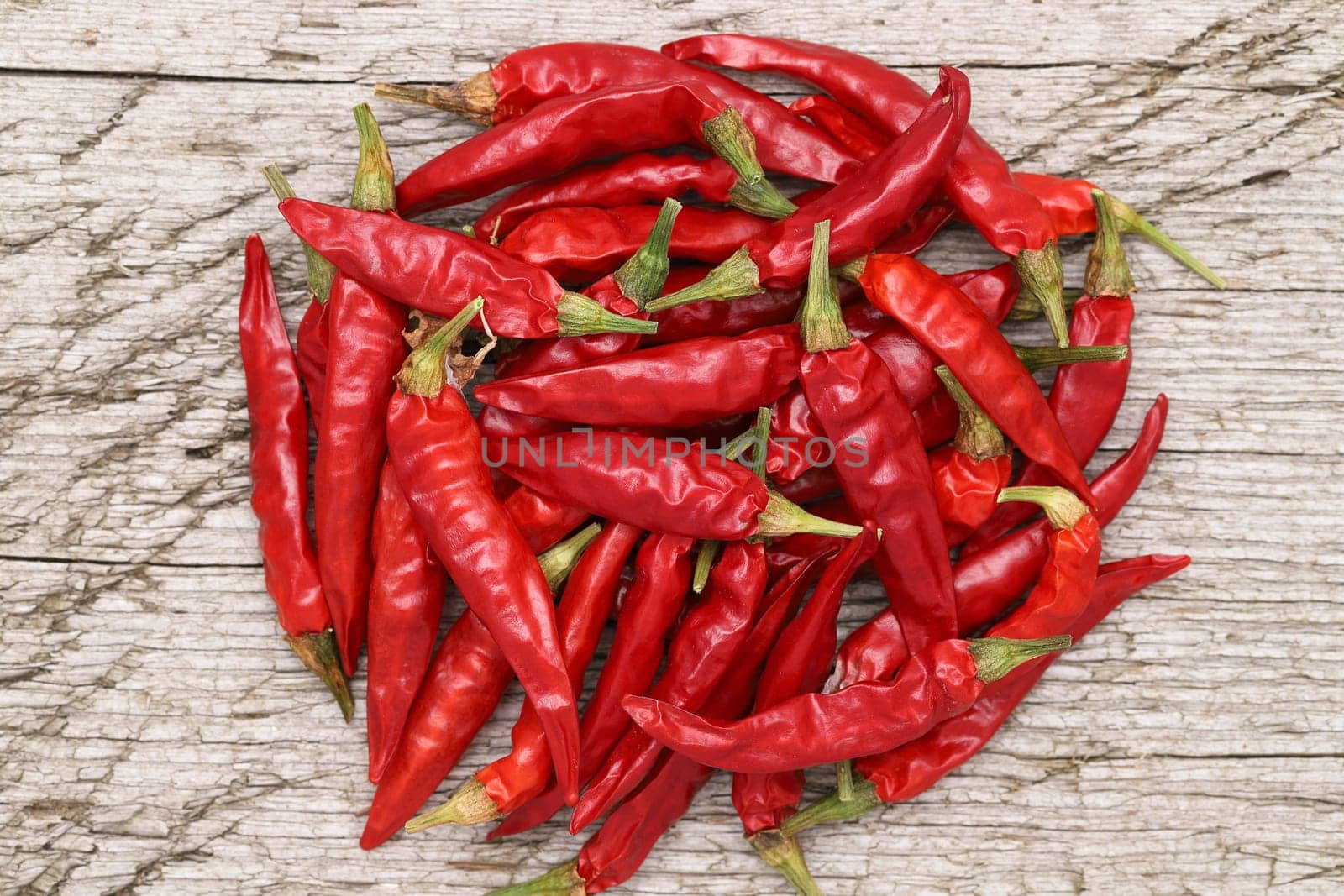 stack of red chili pepper plants on grungy wooden background