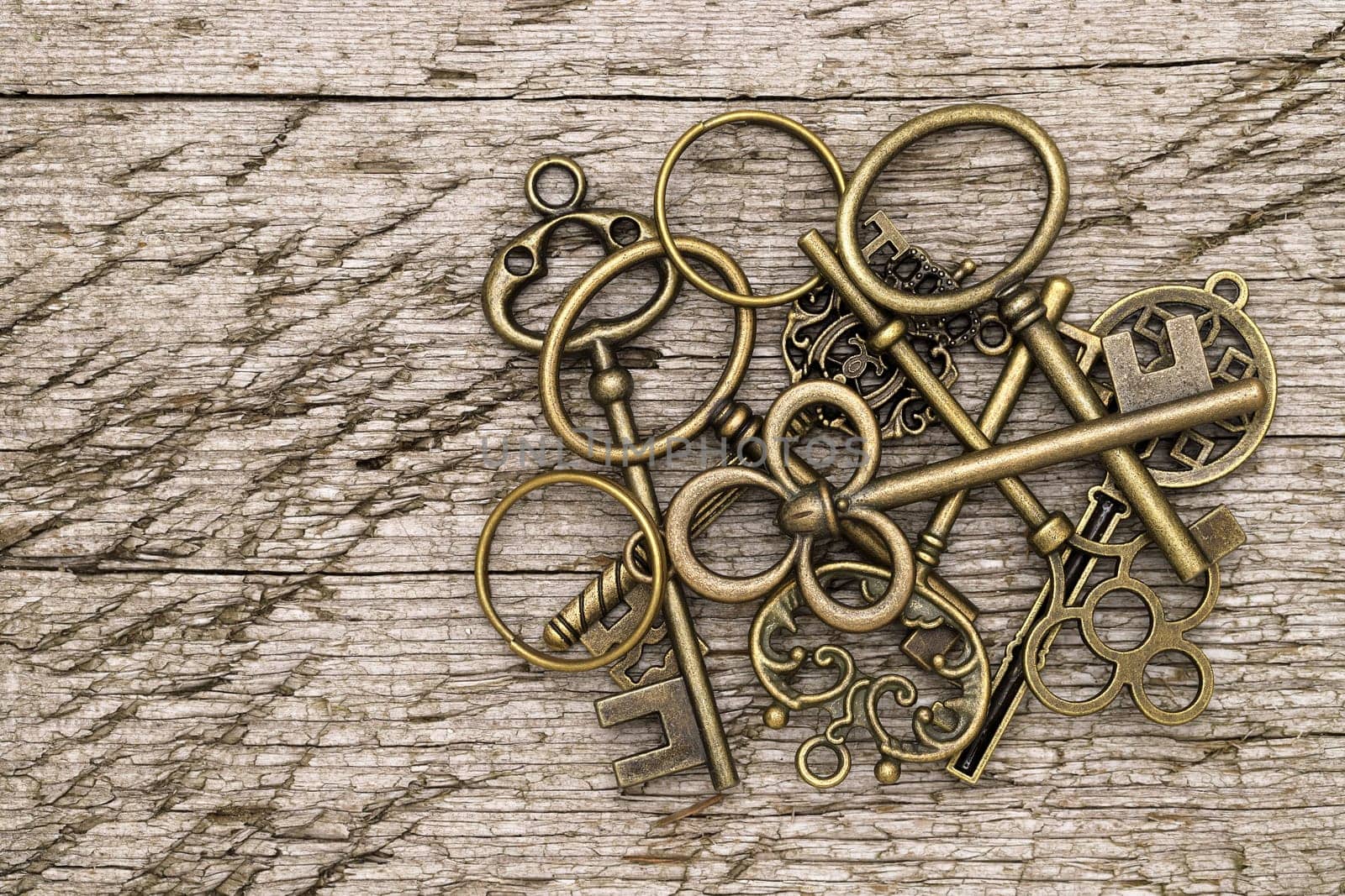 stack of golden vintage key on grungy wooden background