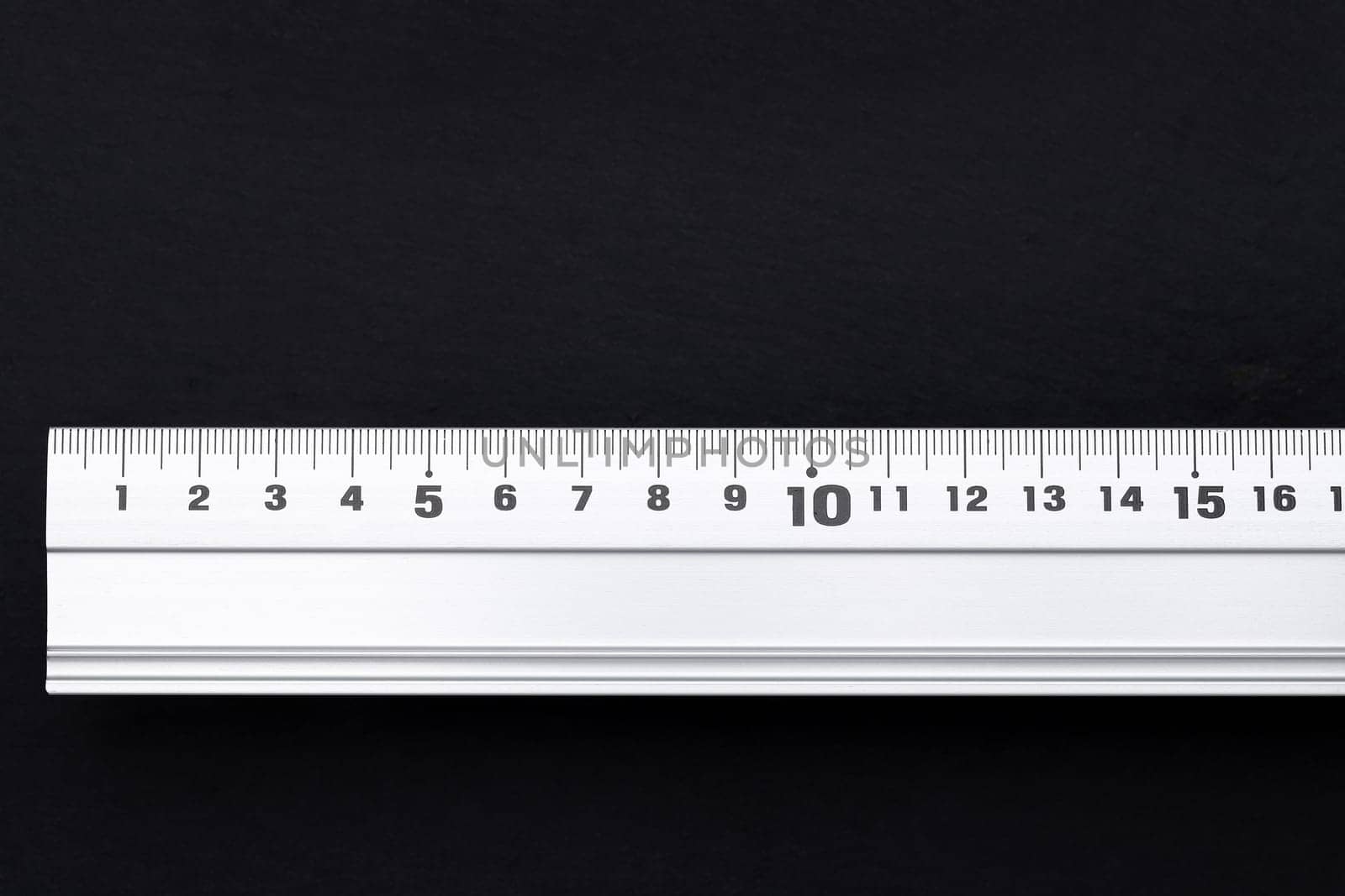 close up of steel ruler on black background