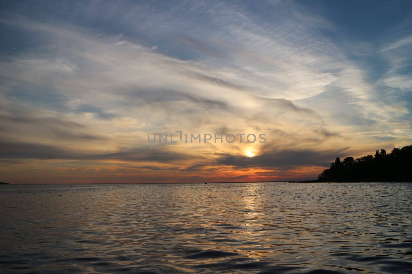 picturesque sunset, bizarre clouds illuminated by the setting sun, sea view