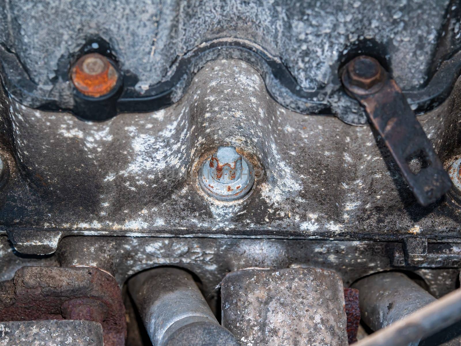 Old rusty metal car engine mounting bolt. Bolt and nut. Metal fastening. Threaded connection of steel parts. Engine part. Car repair. Transport service. Locksmith work. Repair shop.