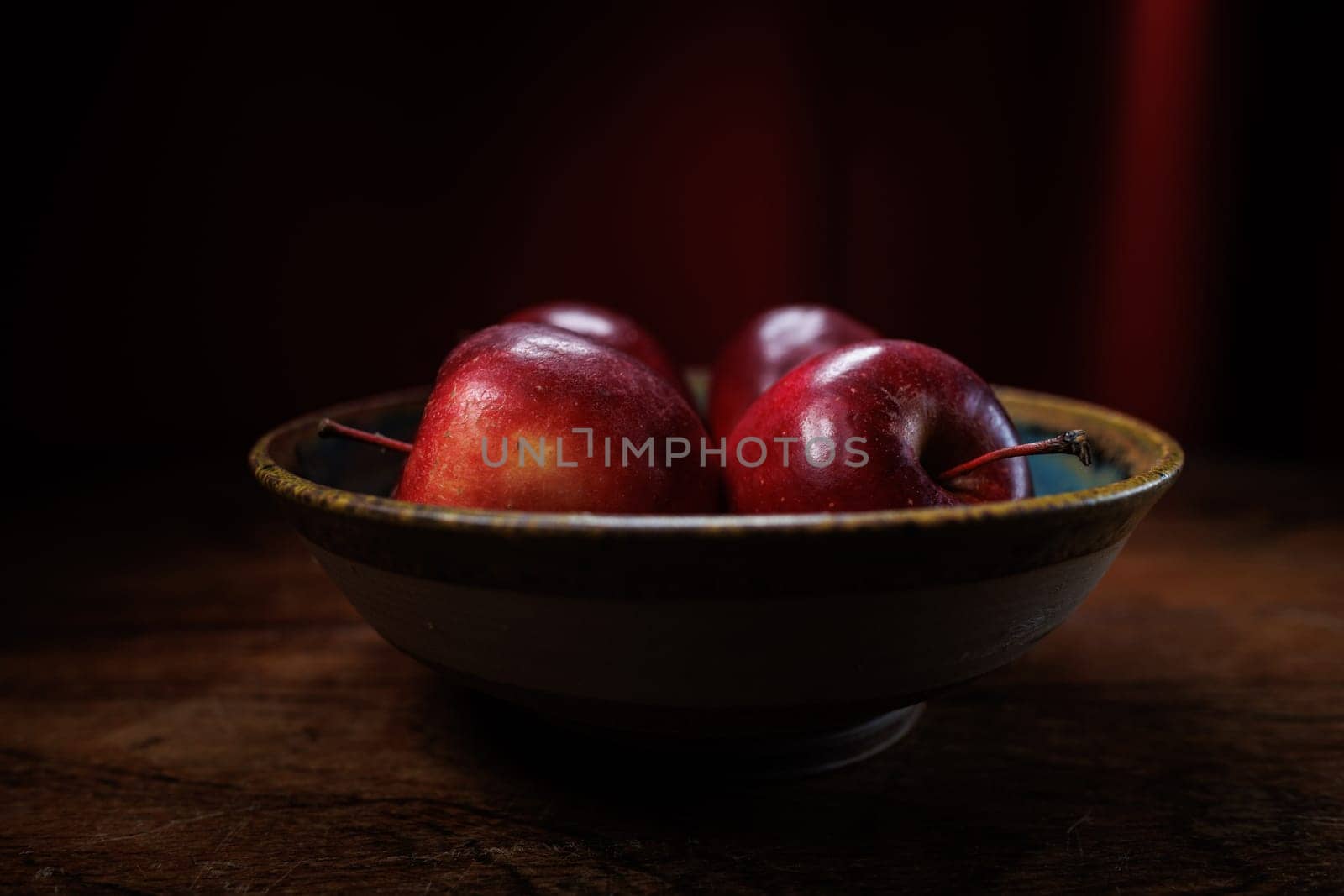 4 red apples in clay bowl
