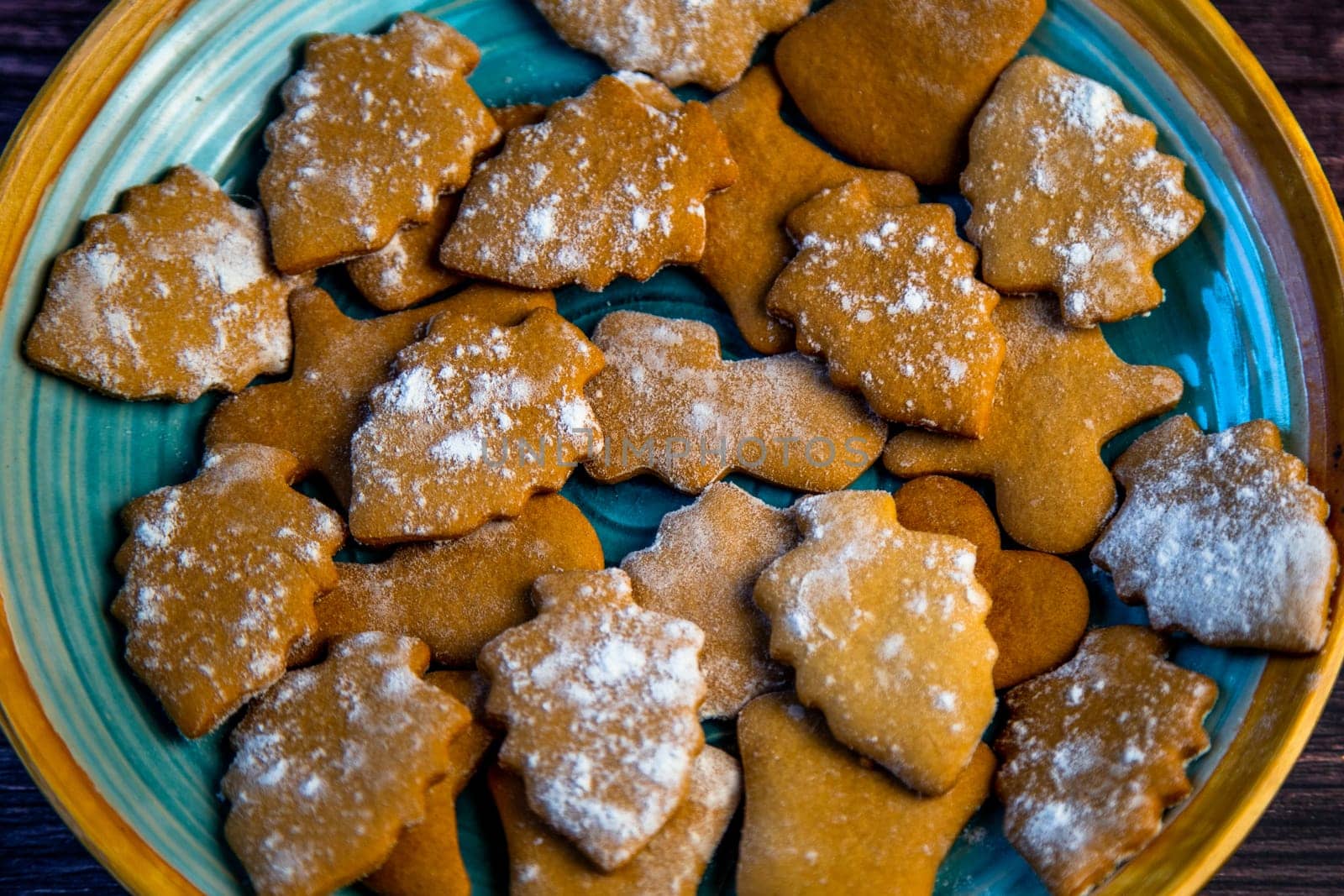 Cookies in the form of Christmas trees are lying on a blue plate close-up. High quality photo