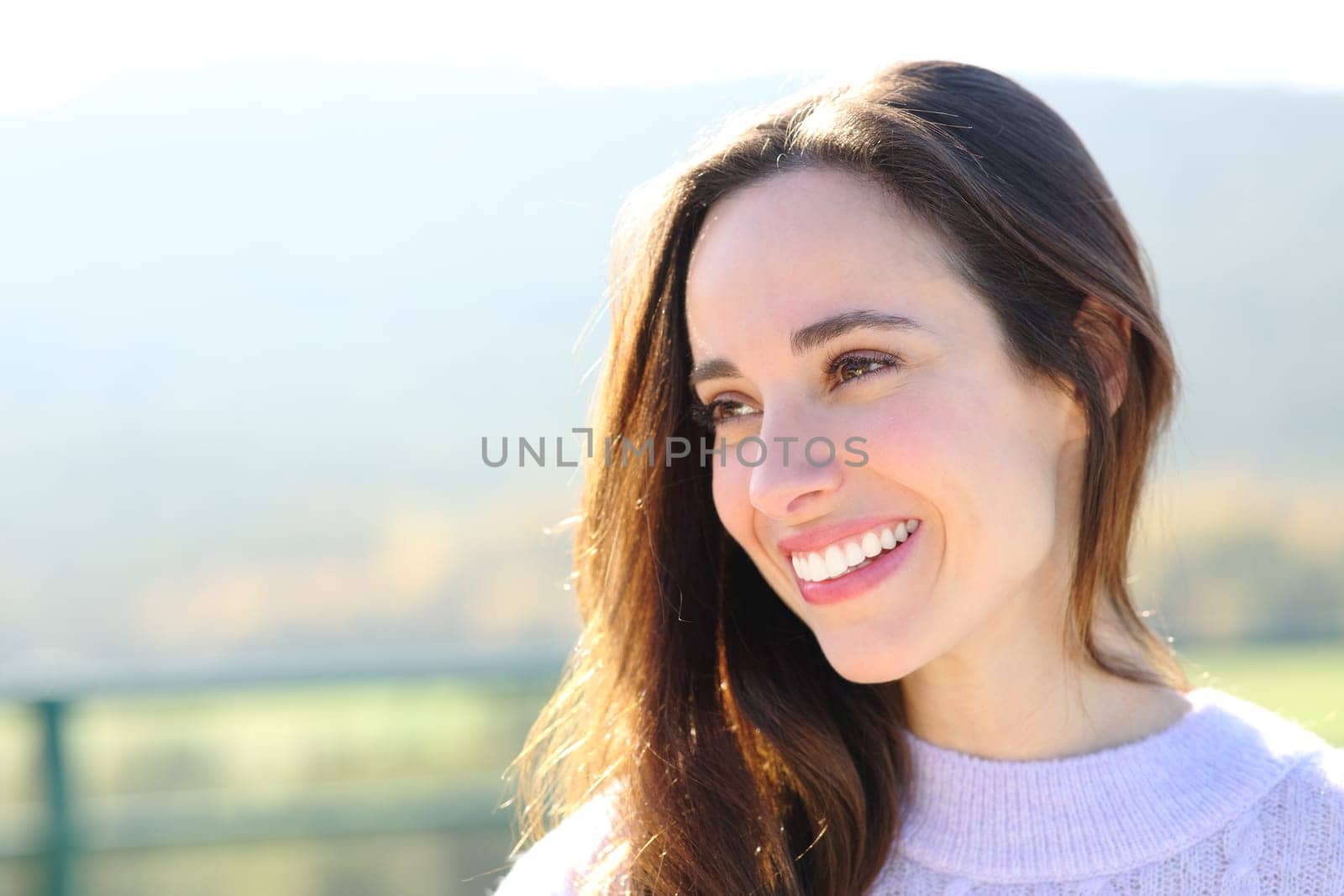 Portrait of a happy woman with perfect smile looking at side in the mountain
