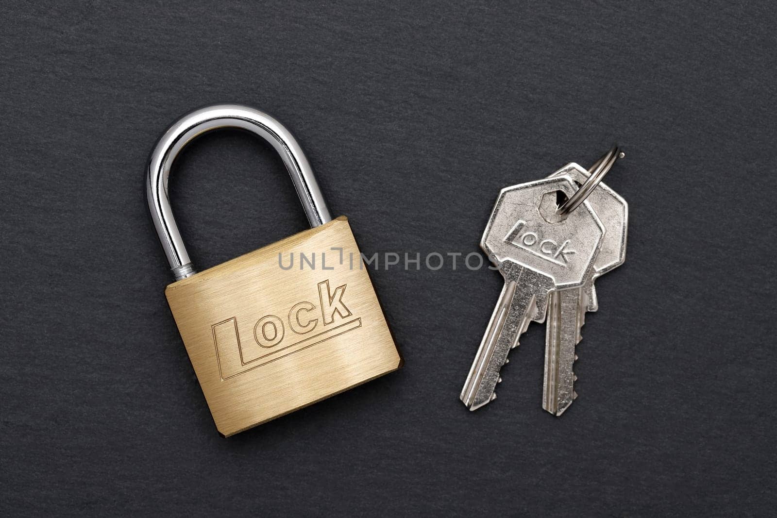 Steel padlock with key on a black background